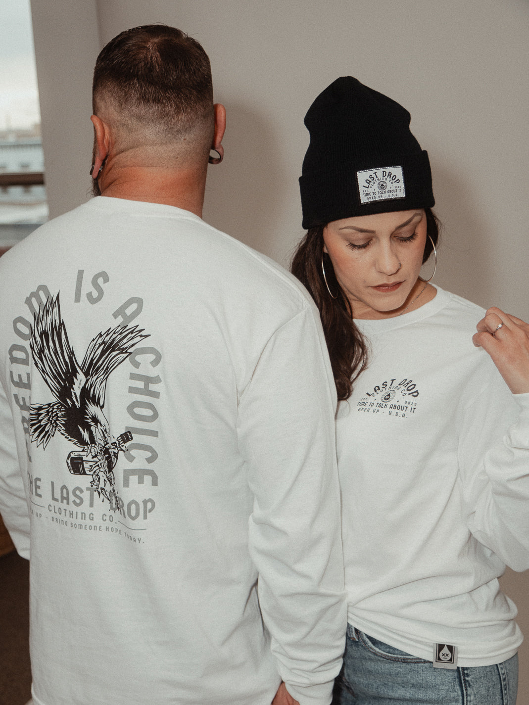 A man and woman proudly showcase their independence and strength as they wear white long sleeve t-shirts adorned with a majestic eagle symbolizing freedom.