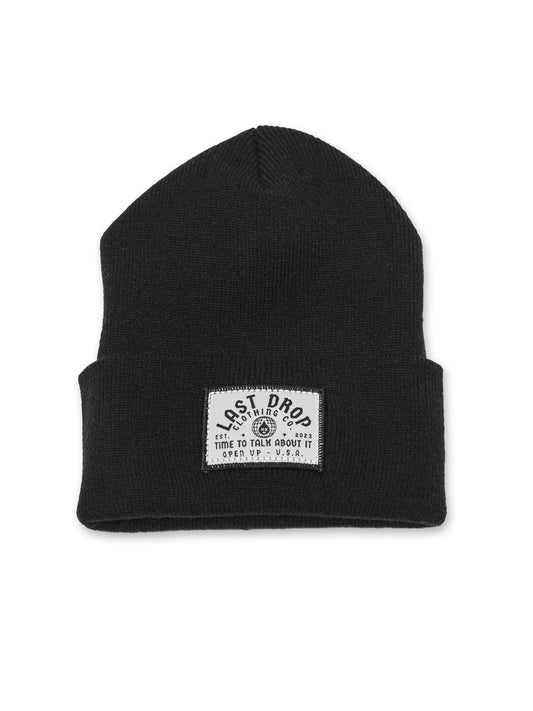 A black beanie with a white patch on it, showcasing personality with a global embroidered patch and crafted using high-quality materials.
